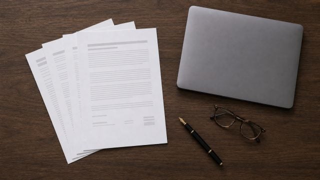 A solicitor dictating at a desk while an AI scribe drafts an attendance note and engagement letter from the speech.